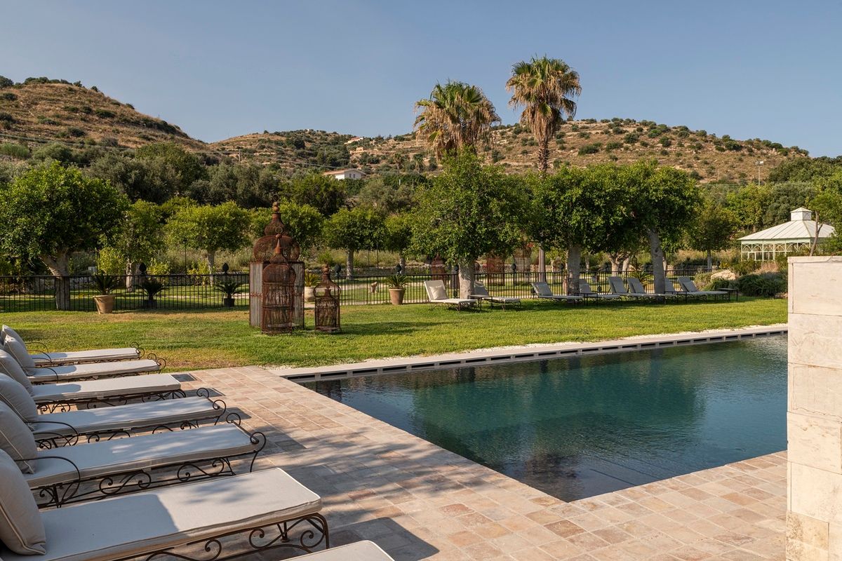 Piscina con lettini tra gli agrumeti e le colline della Val di Noto